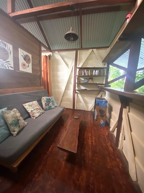 Cozy timber living room with a futon and bookshelf in a tiny house