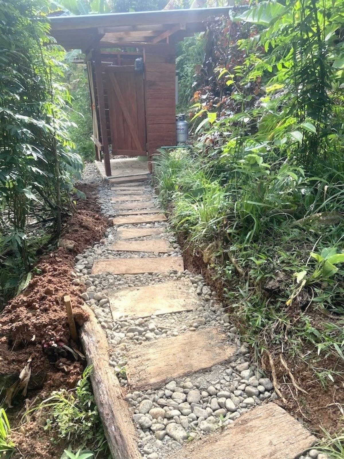 Stone path leading to a hardwood bathroom cabin